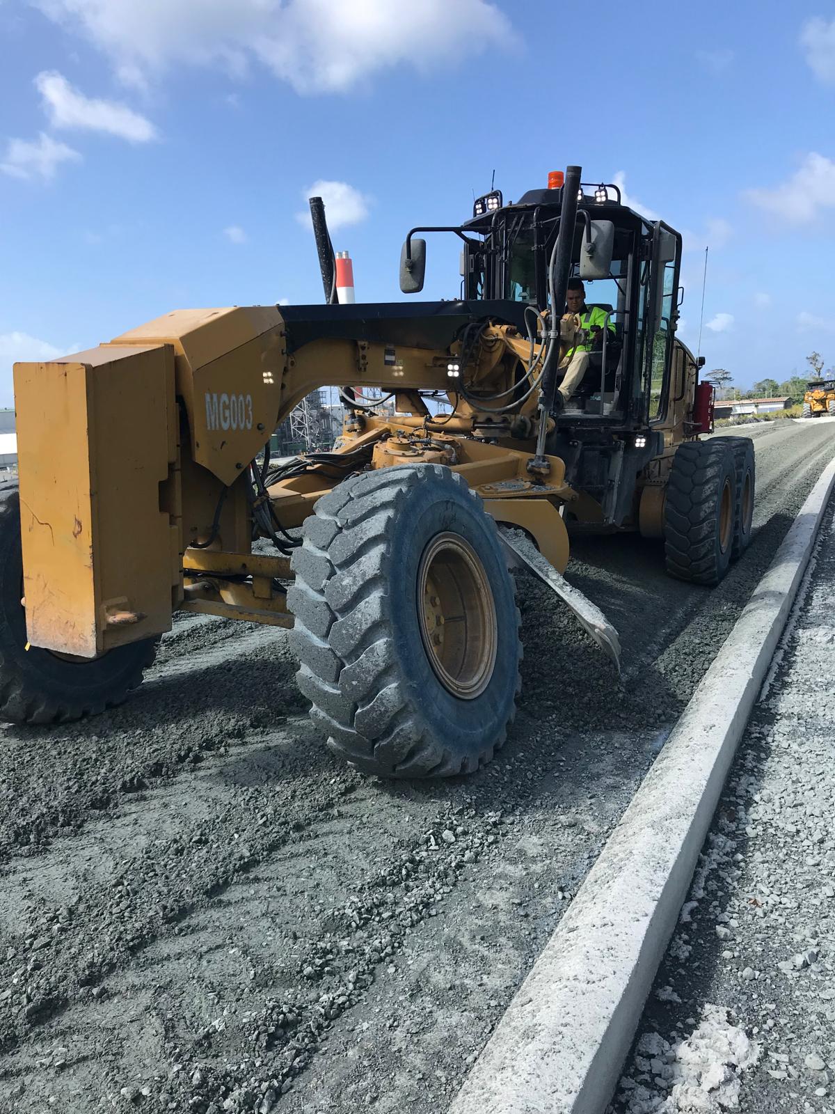 CAT motor grader shaping a freshly treated base course