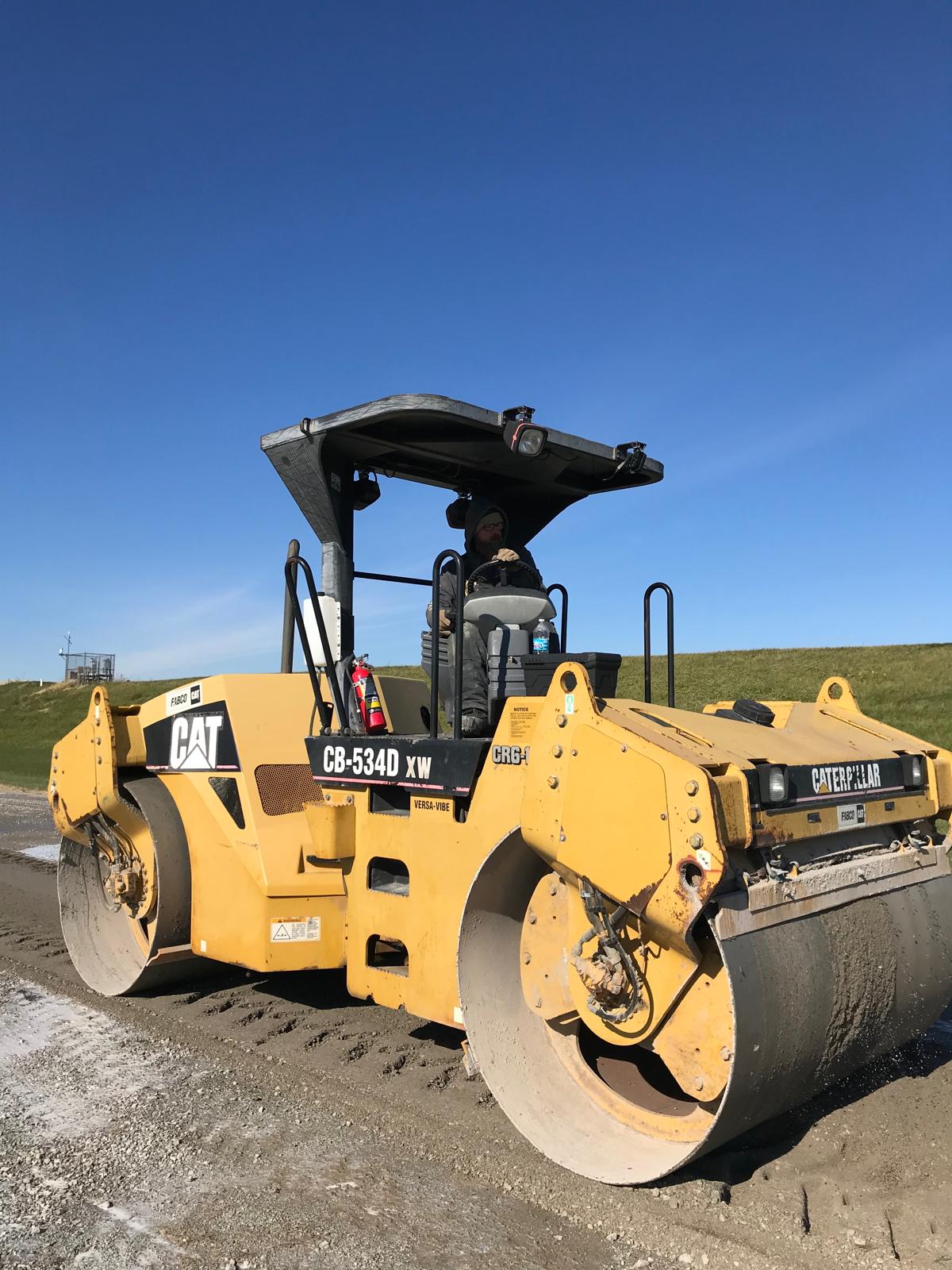 CAT CB-534D double-drum tandem roller staged for the first compaction pass