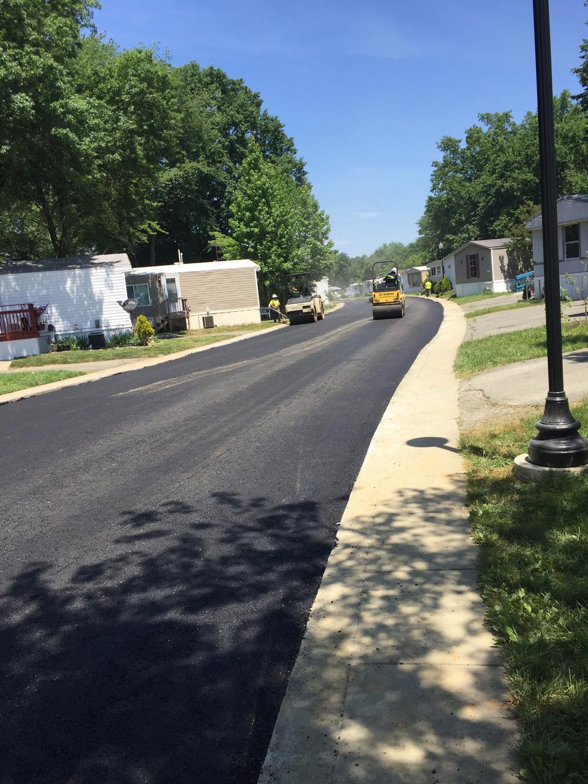 Tandem roller mid-shift on the final compaction pass on a residential street