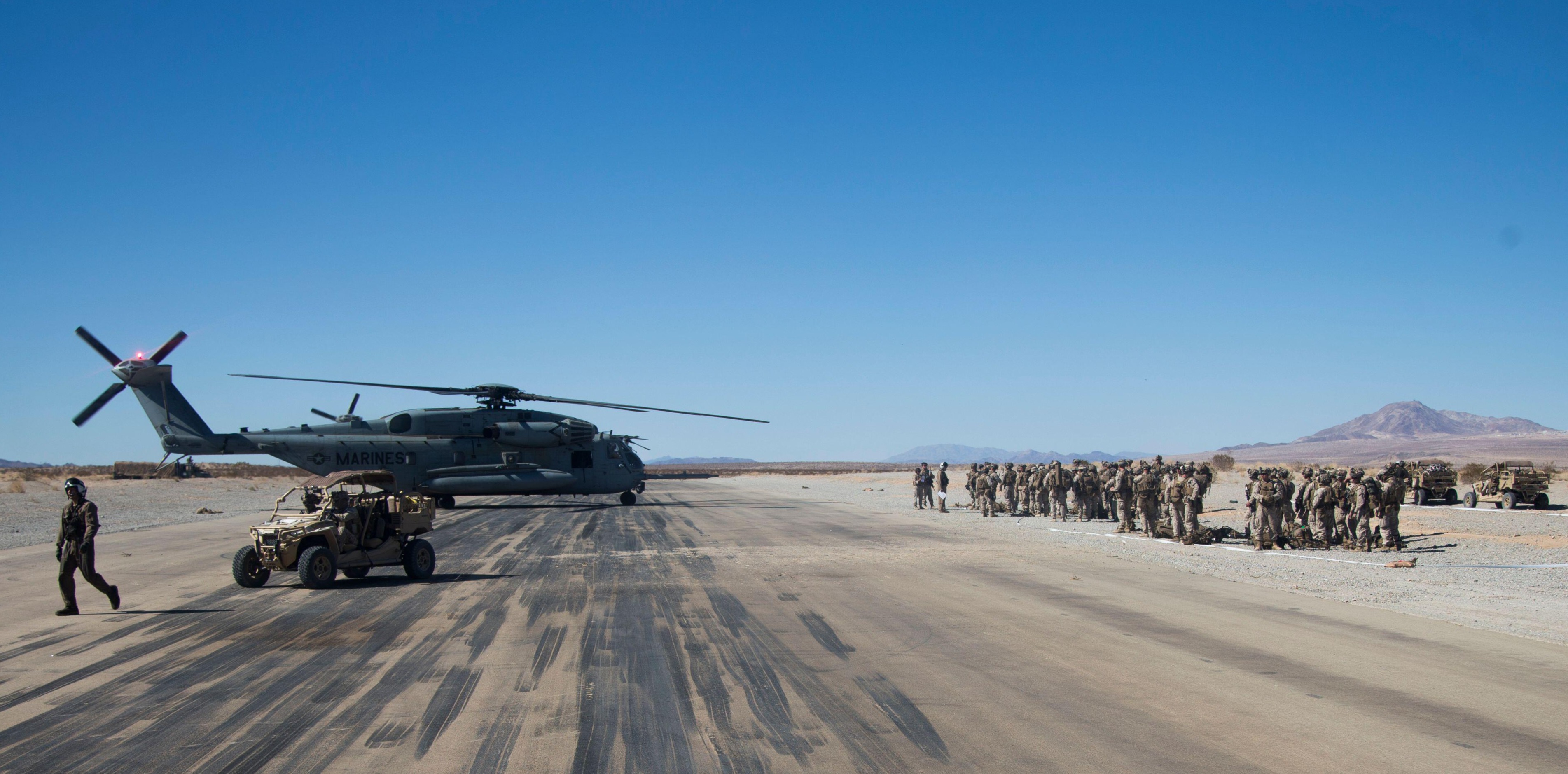CH-53 heavy-lift helicopter and Marine formation on a stabilized pad